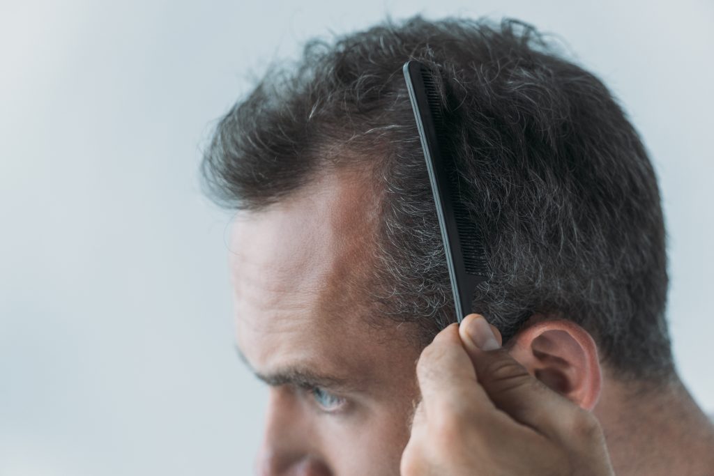 close up view of mid adult man combing hair with c 2026 01 06 00 43 41 utc